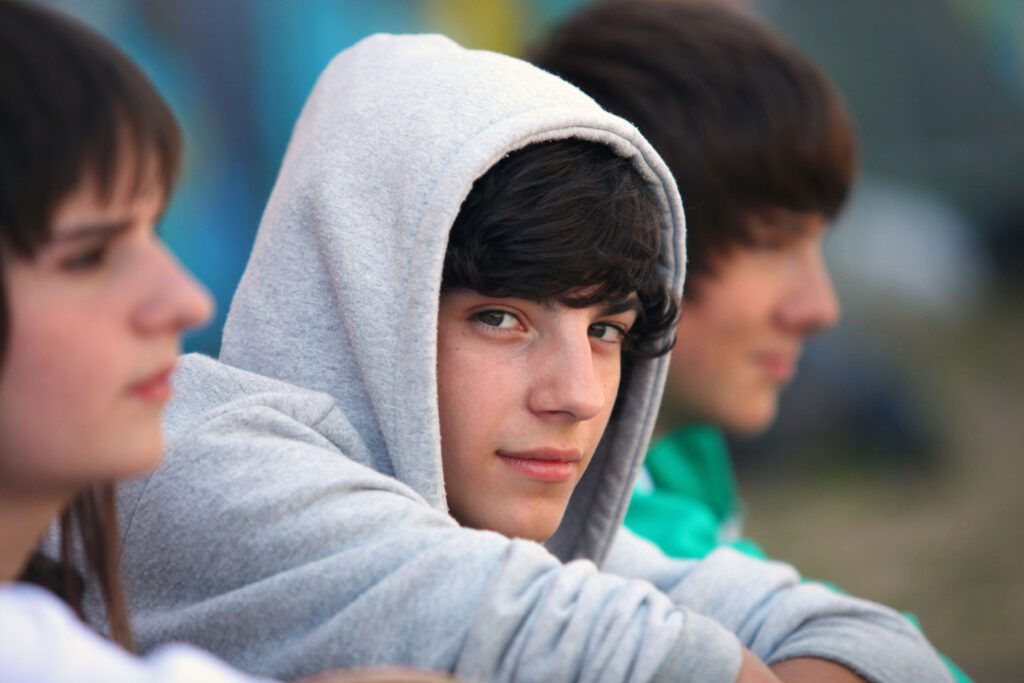 Teen boy wearing a gray hoodie.