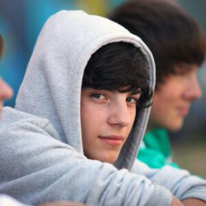 Teen boy wearing a gray hoodie.